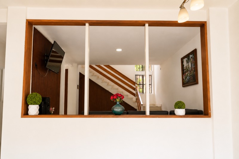 Interior de la casa con escalera, entrepiso y ventana