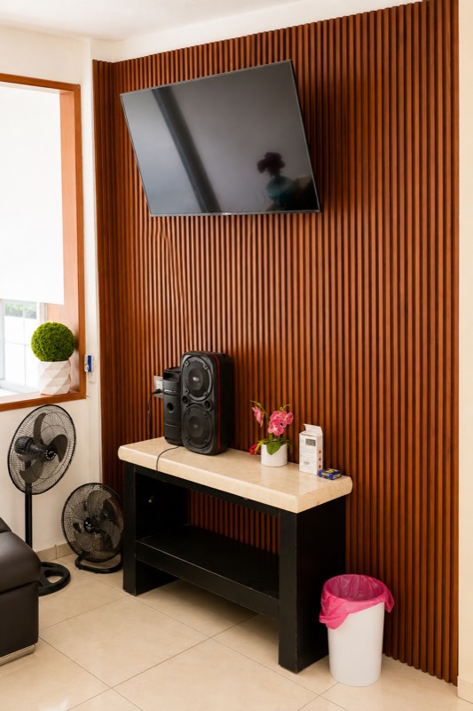 Muro de televisión con bocinas y listones de madera