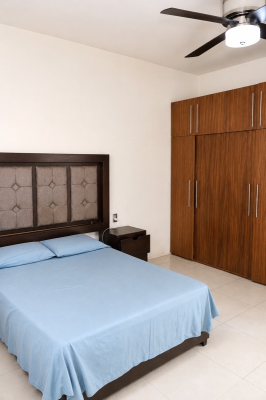 Recámara con clóset de madera y cama azul